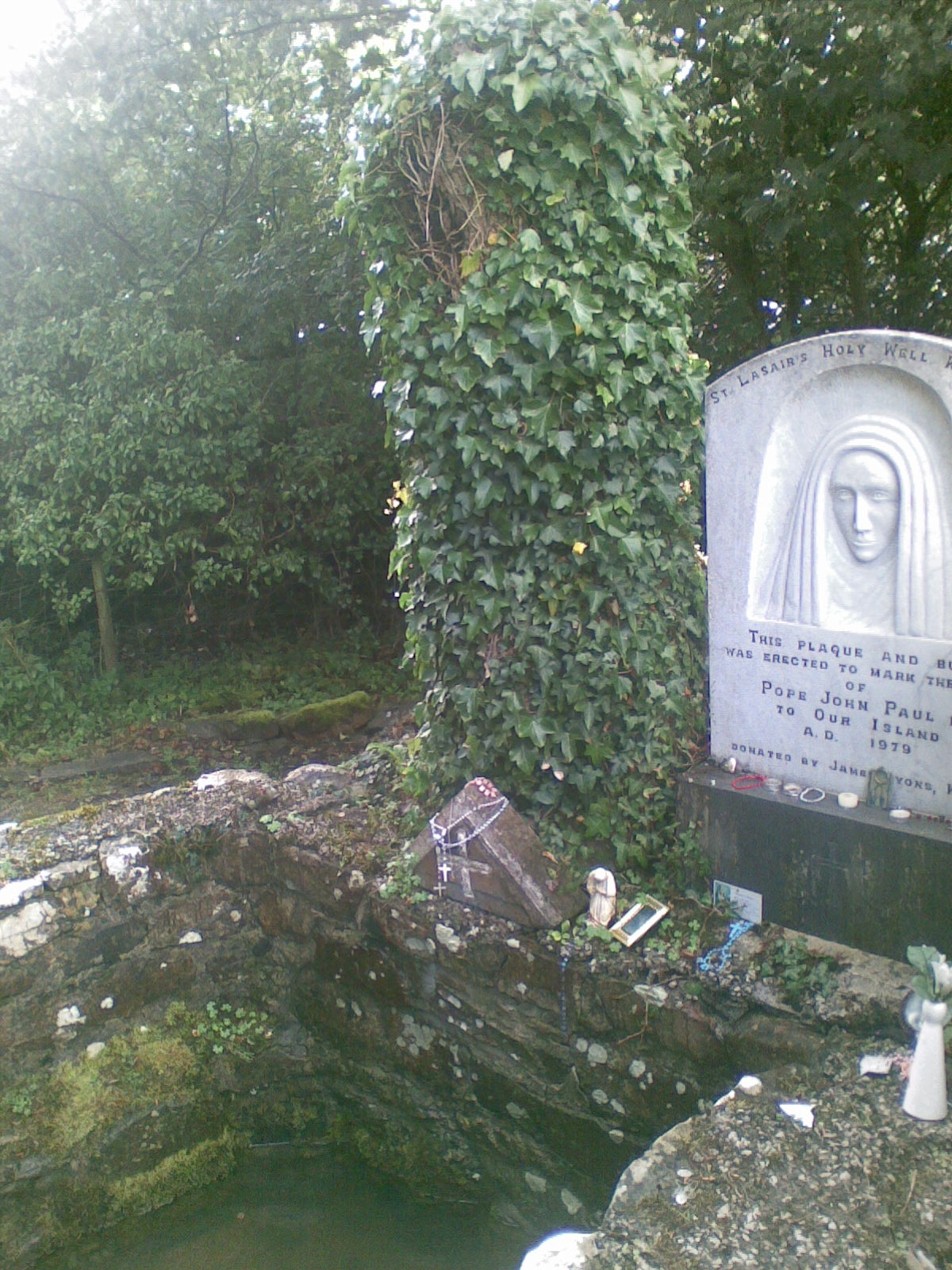 The stone around the well, with offerings left behind